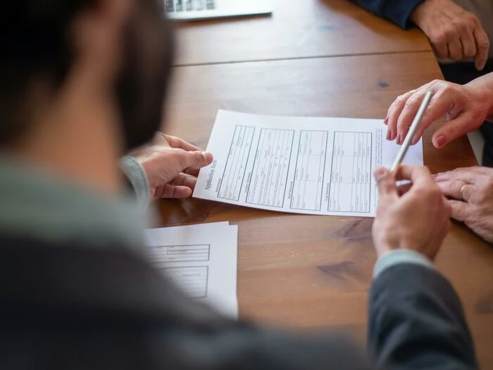 an agent handing a pen to a client