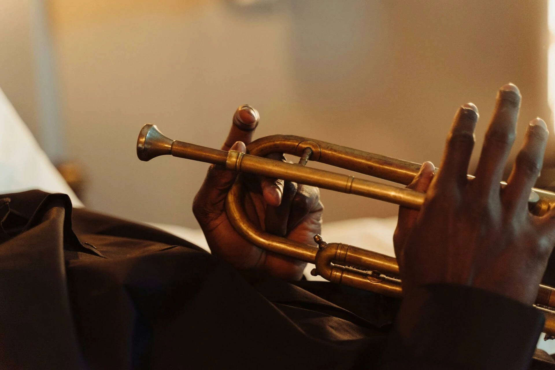 artistic closeup of hands holding a brass trumpet showcasing musical craftsmanship