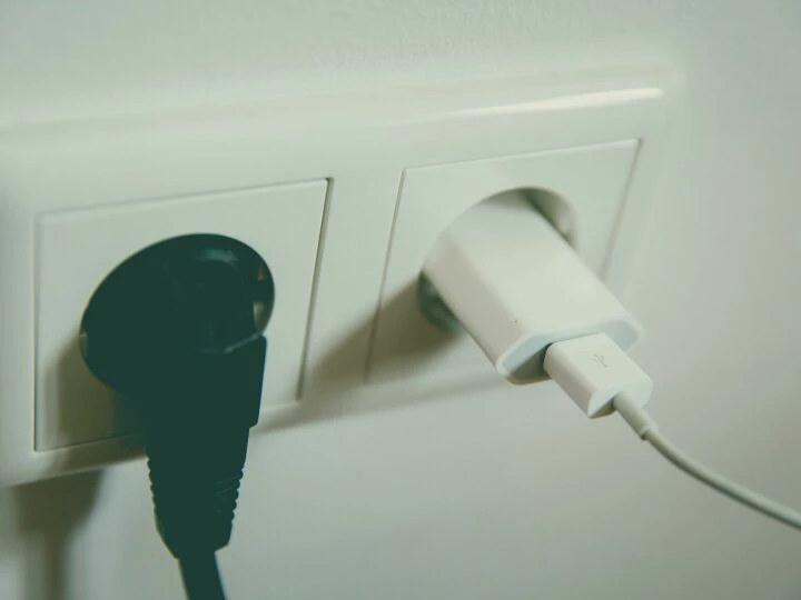 A close-up view of a wall outlet with two plugs inserted, capturing the simplicity of electrical connectivity.