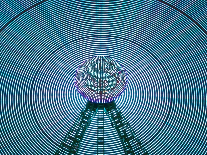 Abstract image of a digital dollar sign surrounded by neon concentric circles, representing fintech innovation and defence funding