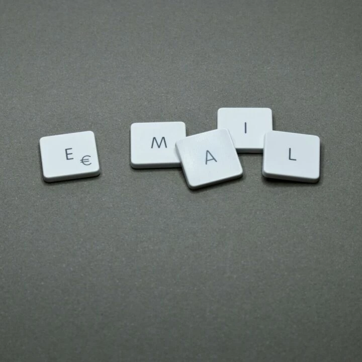 Close-up of the word 'email' formed with letter tiles on a gray surface.
