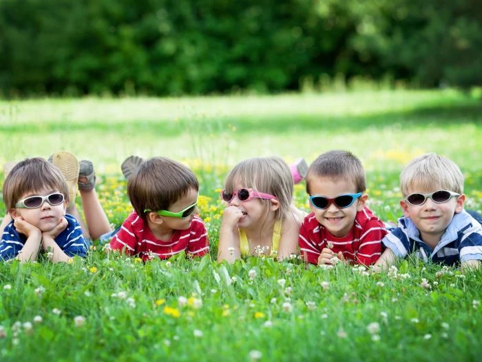 five children in sunglasses on grass