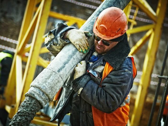 man carrying gray pipe