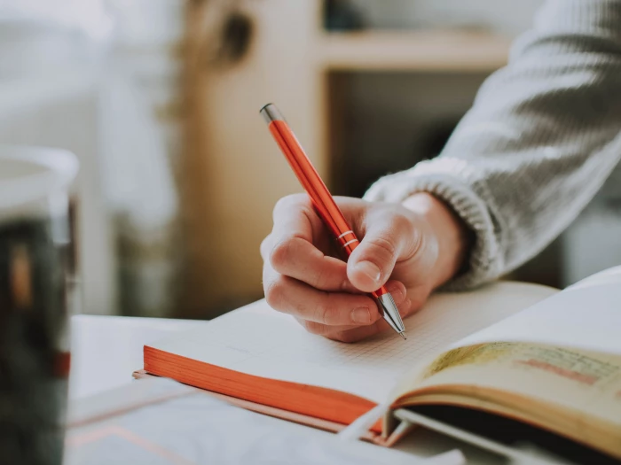 person holding orange pen