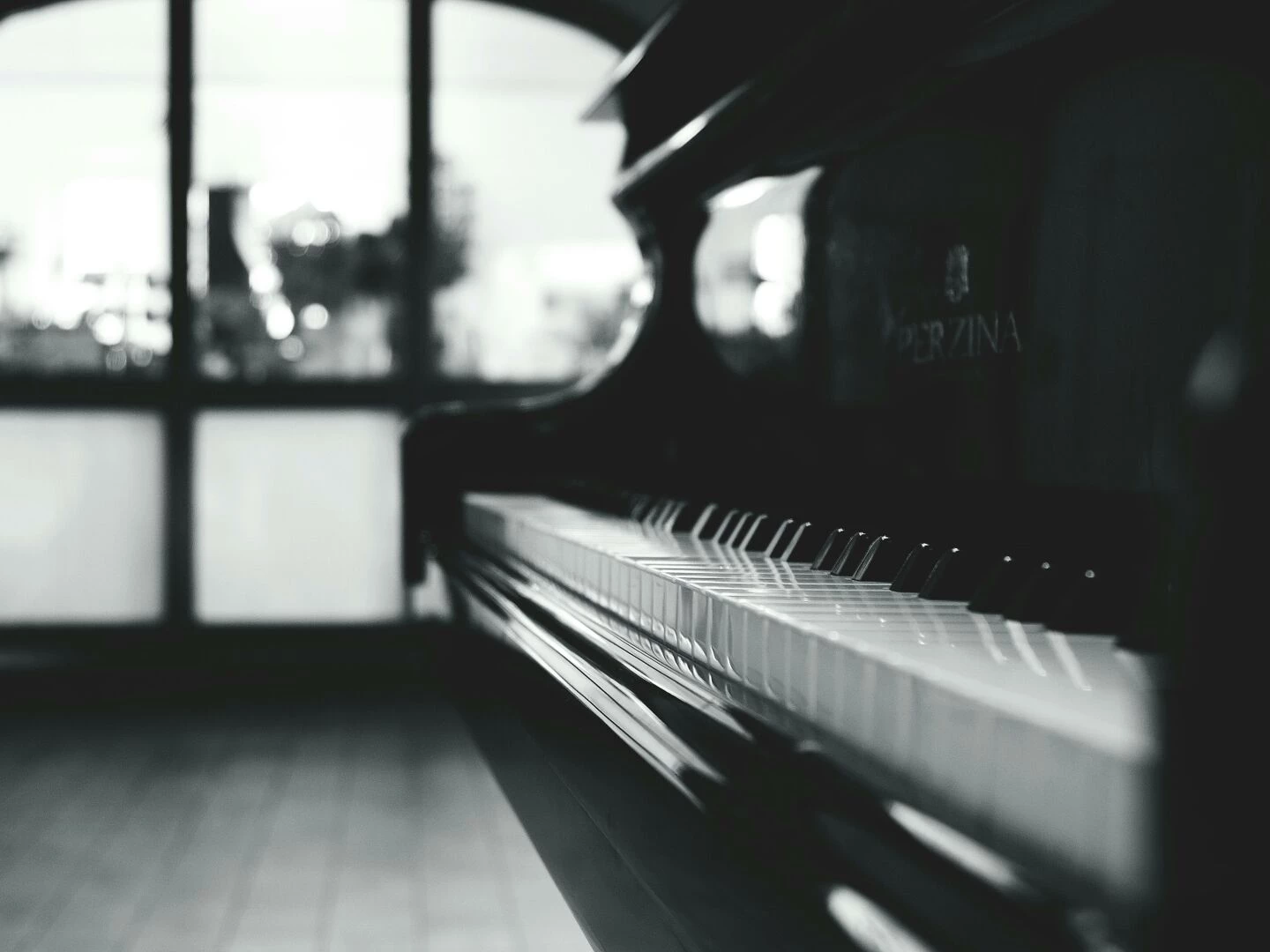 stylish black and white closeup of a piano inside a room with soft lighting